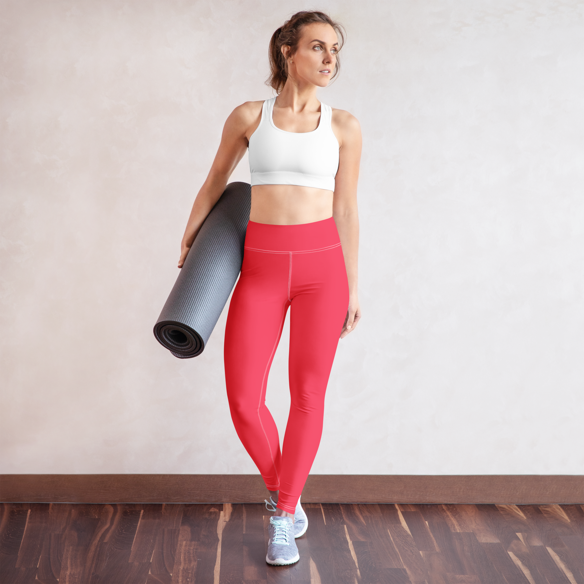 femme avec un tapis de sport sous le bras en legging rose