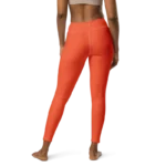 Legging de sport pour femme orange en nylon Éconyl, tissu léger sans couture, effet seconde peau pour un confort optimal. Photo porté du produit de derrière.