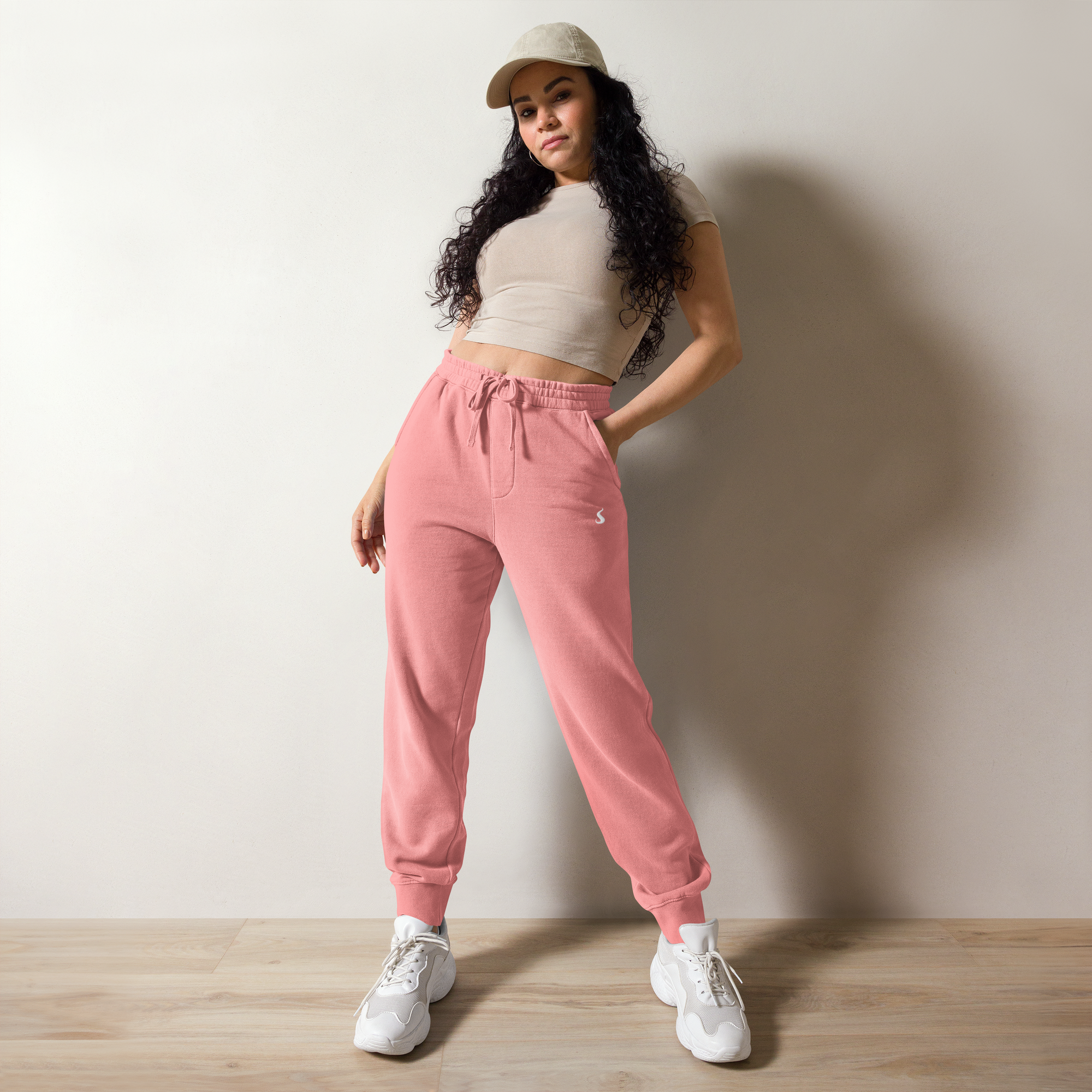 une femme portant un jogging rose avec une main dans la poche