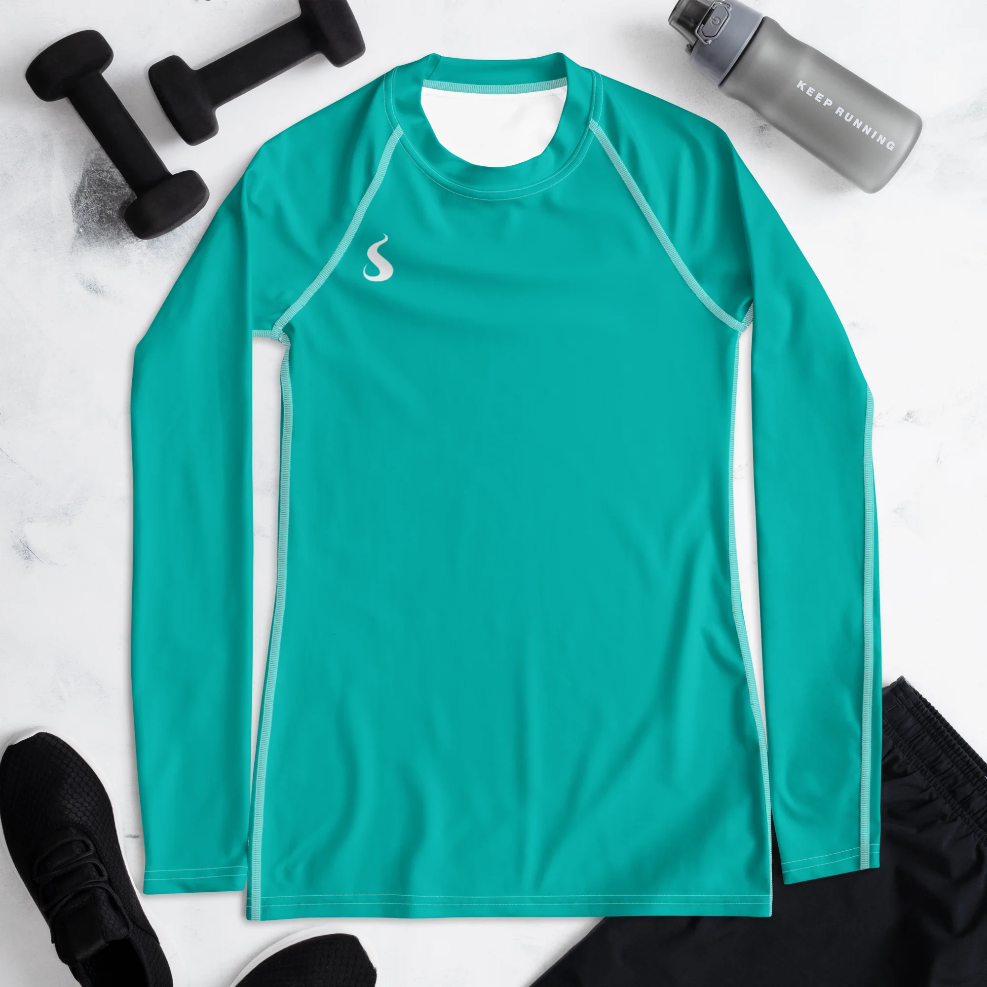 T-shirt manche longue Energy Flow de couleur bleu turquoise en matière lyocell tencel et modal. La photo montre le t-shirt de face dans un décor sportif avec des poids et une gourde pour présenter le produit.