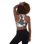 Brassière de sport Sweat Hold Up en nylon Econyl, douce et respirante, avec dos nageur pour un maintien léger. Disponible dans plusieurs motifs. Photo porté de dos par le mannequin avec le motif Tie and dye noir et blanc.