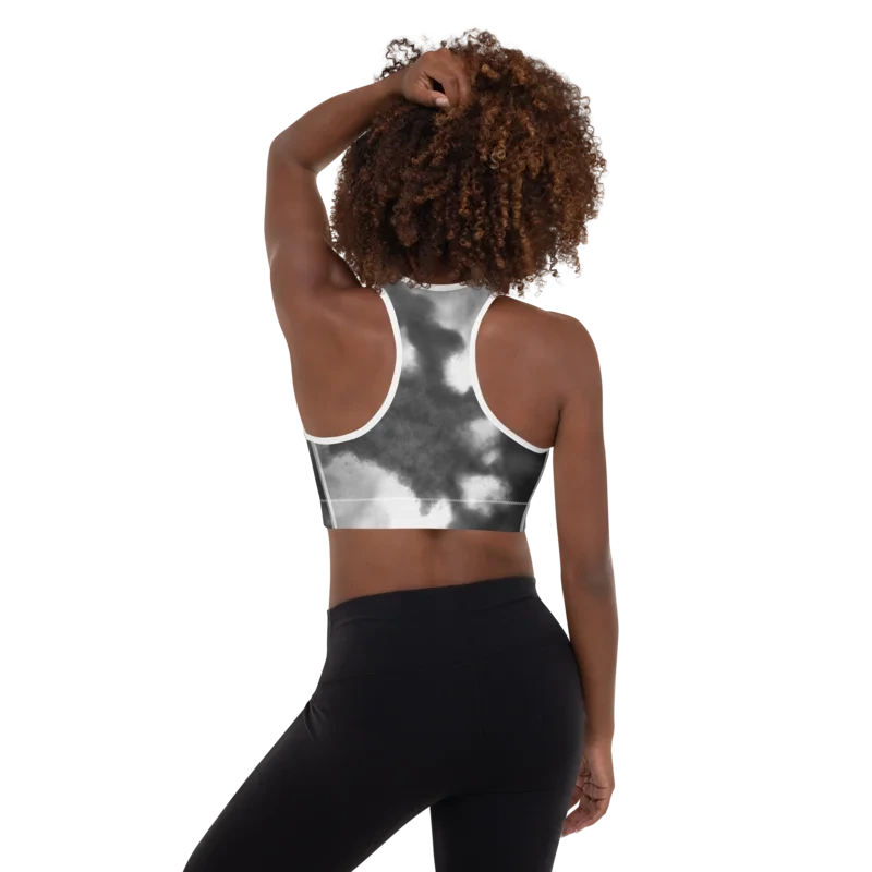 Brassière de sport Sweat Hold Up en nylon Econyl, douce et respirante, avec dos nageur pour un maintien léger. Disponible dans plusieurs motifs. Photo porté de dos par le mannequin avec le motif Tie and dye noir et blanc.