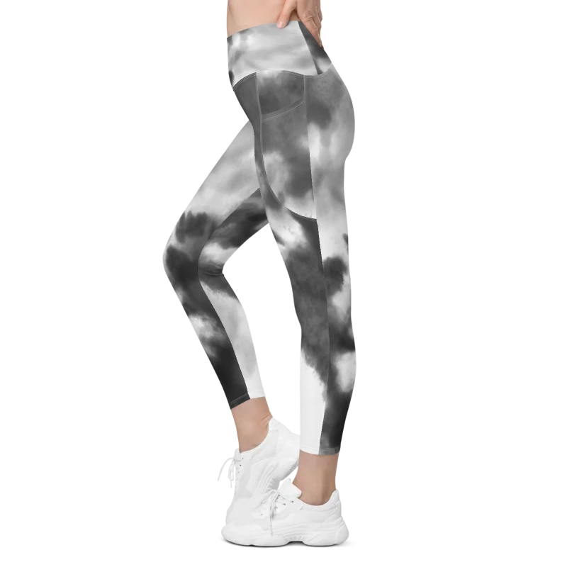 Legging de sport pour femme taille haute avec double poche à motif tie and dye "effet nuage" en noir, gris et blanc. Coupe taille haute pour un effet sculptant et un maintien optimal. Photo porté du produit de côté.