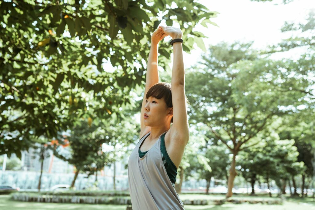femme faisant du yoga dans un parc arboré